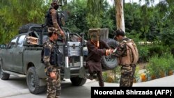 Forces with Afghanistan's National Directorate of Security (NDS) escort alleged Taliban and Islamic State fighters after they are presented to the media in Jalalabad on May 23.