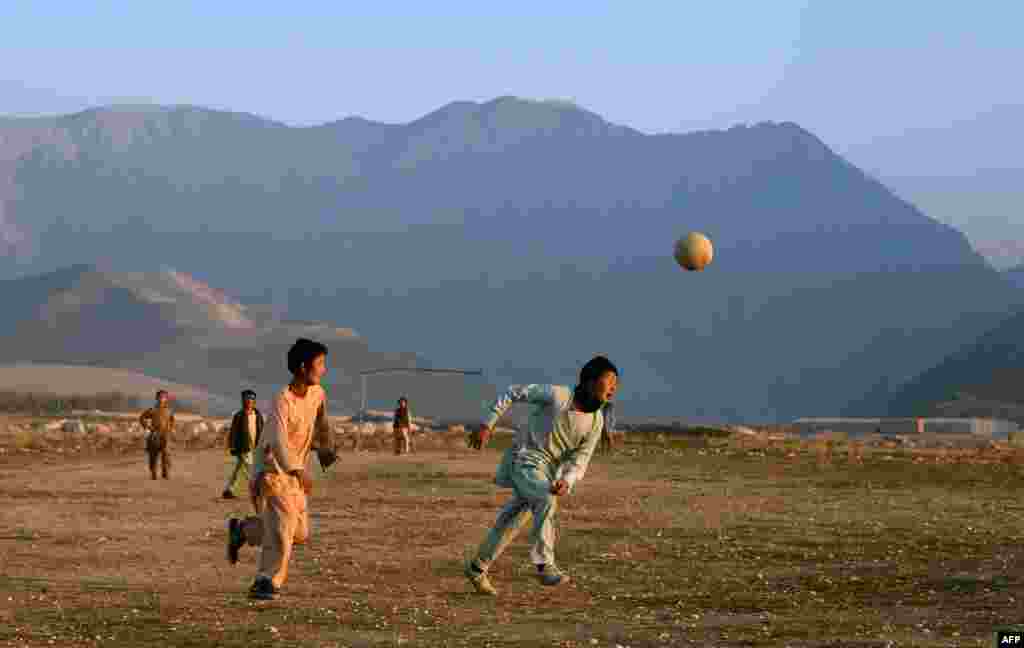 Afghan children play football in a field in a village on the outskirts of Mazar-e Sharif. (AFP/​Farshad Usyan)