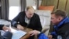 Ukraine -- Russian President Vladimir Putin (C) talks to Deputy Prime Minister Dmitry Kozak (L) and head of the Federal Road Agency (Rosavtodor) Roman Starovoit as they inspect a transport passage across the Kerch Strait, Crimea, March 18, 2016