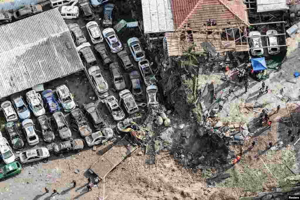 На снимке, сделанном с помощью дрона, запечатлены израильские сотрудники служб безопасности и спасатели, работающие на месте падения ракет после иранских ракетных обстрелов, Израиль, 28 марта 2026 года. REUTERS/Ilan Rosenberg