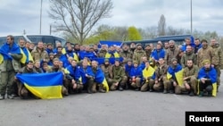 Ukrainian prisoners of war pose for a picture after an exchange with Russia at an unknown location in Ukraine on April 16.