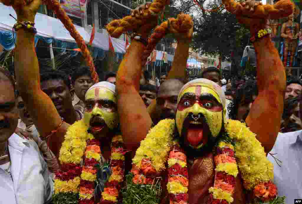 Indian Hindu devotees representing Potharaju, brother of the goddess Mahankali, dance in the streets during the Bonalu festival at the Sri Ujjaini Mahakali Temple in Secunderabad, the twin city of Hyderabad. (AFP/Noah Seelam)