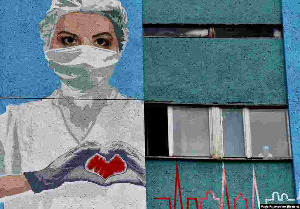 A mural depicting a health-care worker is seen painted on a wall of the City Emergency Hospital in Lviv, Ukraine. (Reuters/Pavlo Palamarchuk)