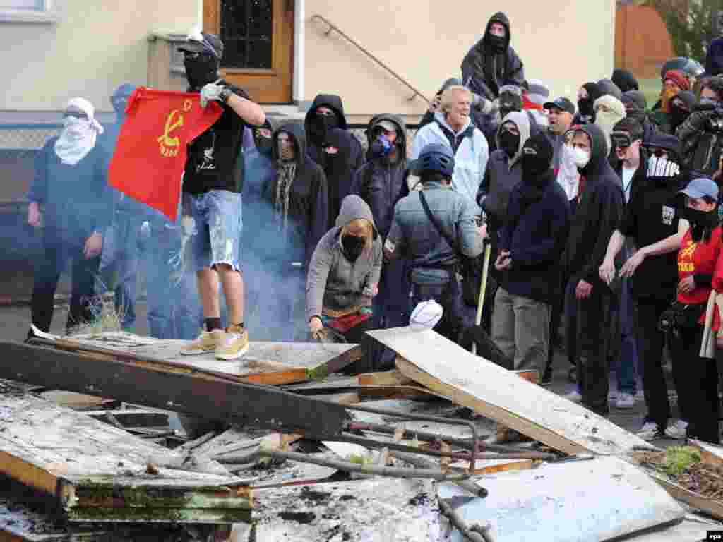 Демонстранти во Стразбур - epa01686734 Hooded protesters man a barricade against the NATO Summit in a street in Strassbourg, France, 03 April 2009. The 2009 NATO summit will take place in Baden-Baden and Kehl, Germany and Strasbourg, France on 03 and 04 April 2009. Left wing demonstrators and riot police forces repeatedly clashed over the course of the day.