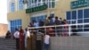 People wait outside a Western Union branch in Turkmenistan. Money transfers abroad in the Central Asian country of some 5.8 million are primarily carried out by Western Union shops located inside official bank premises, which operate under strict government control. (file photo)