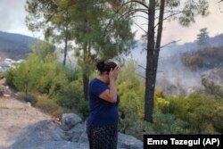 O femeie privește cu disperare urmările incendiilor ce au cuprins sud-vestul Turciei.