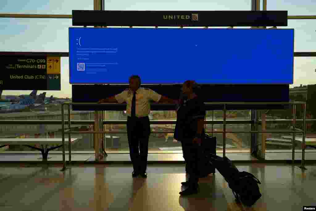 Aeroportul Internațional Newark, New Jersey, SUA &ndash; angajați al United Airlines așeaptă lângă un monitor din Terminalul C, care arată &bdquo;blue error&rdquo;, defecțiune cunoscută sub numele &bdquo;Blue Screen of Death&rdquo;. 19 iulie 2024.