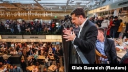 Volodymyr Zelenskiy speaks to someone below during his "press marathon" at a food market in Kyiv on October 10.