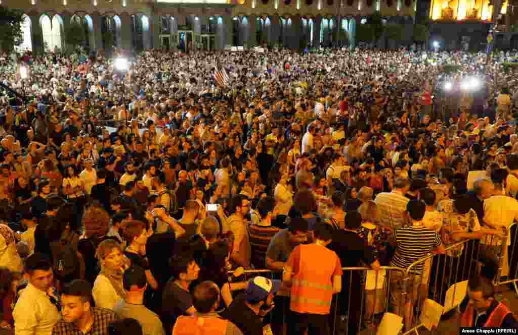 As night fell, protesters gathered outside the parliament building...