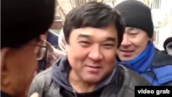 Ыкылас Кабдуакасов (в центре), приговоренный к ограничению свободы по обвинению в разжигании розни, у здания суда. Астана, 9 ноября 2015 года.
