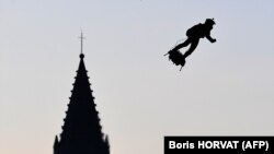 Inventatorul francez Franky Zapata, pe un „skateboard” zburător creat de el, care poate atinge 190 km/oră și cu care în 2019 a evoluat în fața lui Emmanuel Macron la parada militară din 14 iulie, pe Champs-Élysées în Paris. 