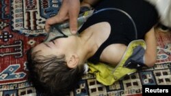 A Syrian boy, affected by nerve gas, breathes through an oxygen mask while receiving medical attention in Damascus. Hundreds of people died in the chemical weapons attack on August 21, 2013