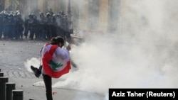 A demonstrator kicks back a tear gas canister during a protest against the government performance and worsening economic conditions, in Beirut, Lebanon June 6, 2020. 