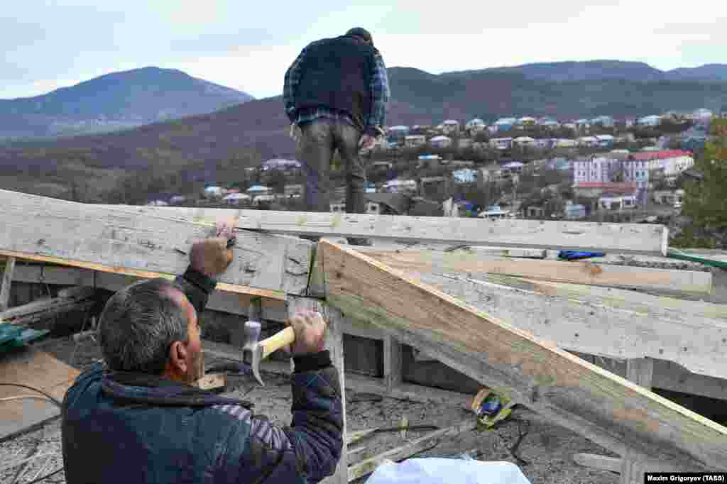 Місцеві жителі ремонтують будинок, пошкоджений обстрілами. У Нагірно-Карабаському регіоні під час бойових дій, в тому числі у результаті ракетних ударів, загинули десятки мирних жителів із обох сторін конфлікту&nbsp;