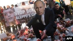 An activist wearing a mask depicting Russian President Vladimir Putin kneels amid color-smeared teddy bears during a protest in front of the Chancellery in Berlin on October 19.