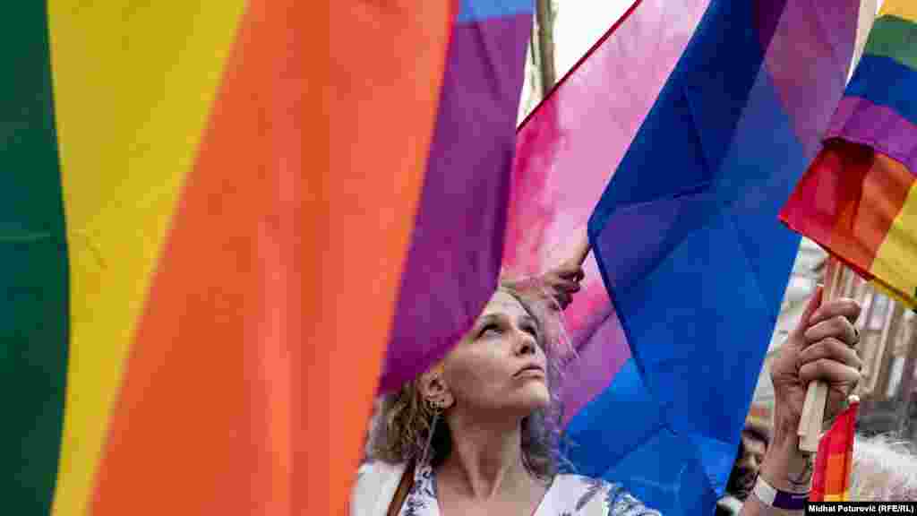 People wave rainbow flags as they march in the first-ever Bosnian gay-pride parade in Sarajevo on September 8, 2019.