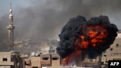 Syria -- A ball of fire rises from a building following a reported air strike by Syrian government forces on a rebel-held area in the southern city of Daraa, June 11, 2017