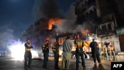 Pakistani rescue and security personnel gather in front of a burning market after sectarian clashes near a Sunni mosque during the Shi'ite Muslim procession in Rawalpindi on November 15.