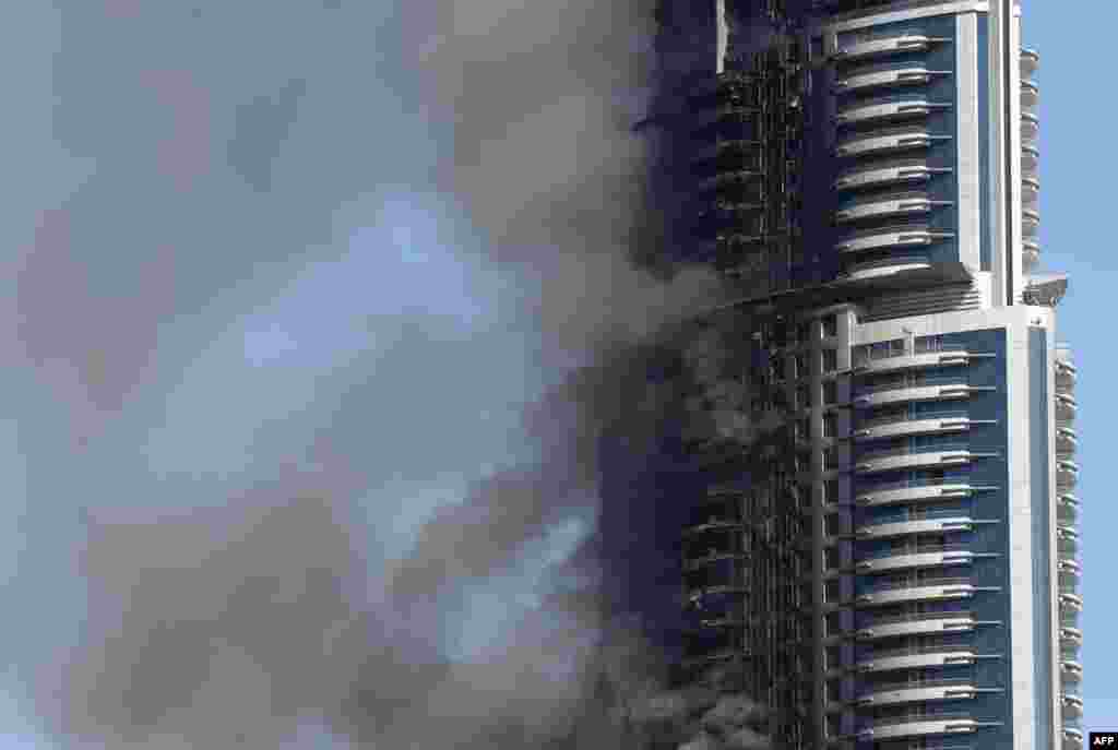 Smoke billows from the Address Downtown Hotel in Dubai on January 1, 2016, in the aftermath of a huge fire that engulfed several floors of the building. (AFP/Marwan Naamani)