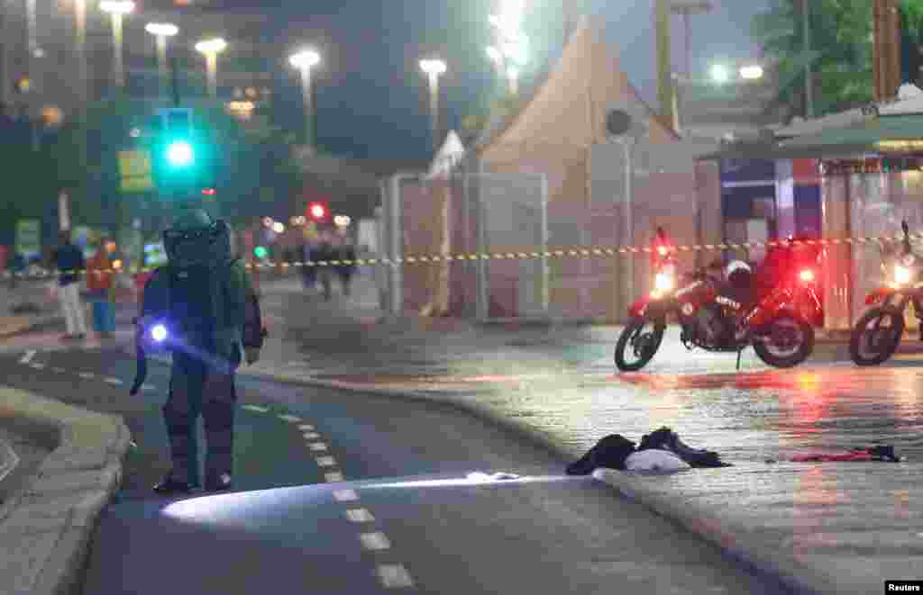 A bomb-disposal expert wearing protective equipment examined a suspect package next to the beach volleyball arena as the opening ceremonies got under way.