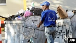 Macedonia -- A man wearing a tee-shirt with the European Union logo collects plastic bottles from trash-containers in the centre of Skopje, 24Jun2013