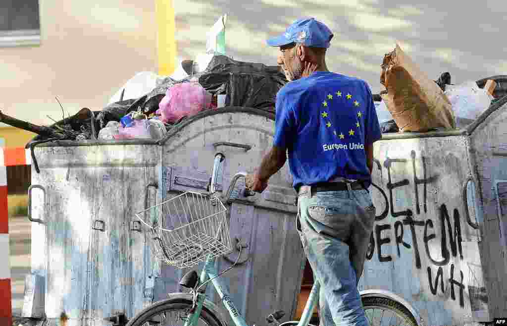 A man wearing a T-shirt with the European Union logo collects plastic bottles from trash containers in the center of Skopje, Macedonia. (AFP/Robert Atanasovski)