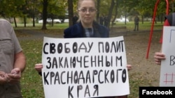 Yana Antonova holds a sign reading: "Freedom to political prisoners of Krasnodar region".