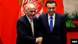 Chinese Prime Minister Li Keqiang and Afghan President Ashraf Ghani (L) pose for pictures during their meeting at the Great Hall of the People in Beijing, October 29, 2015.