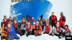 A picture made available on December 29 shows passengers in front of the "Akademik Shokalsky," which got stuck in Antarctic ice, prompting international rescue efforts.