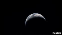 Imagine a Pământului sub formă de semilună luată în timpul călătoriei Artemis II, pe 6 aprilie 2026.