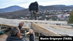 Nagorno-Karabakh -- Local residents repair a roof with construction materials supplied by Russia as humanitarian aid, November 25, 2020.