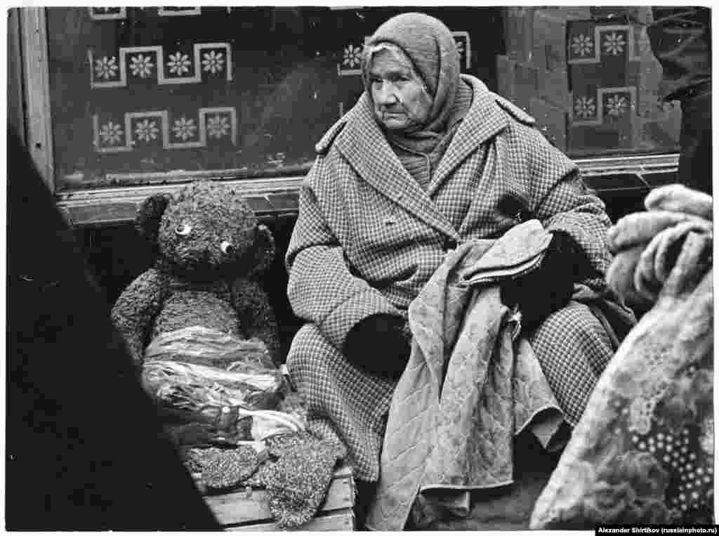 An old woman with a googly-eyed teddy bear. The 1980 photo is titled &quot;Bad Times.&quot;