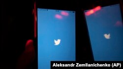 Egy mobiltelefon-használó bekapcsolja a Twitter alkalmazást az okostelefonján Moszkvában 2021. március 10-én