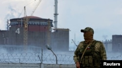 Egy orosz katona áll őrt a Zaporizzsja Atomerőmű közelében az orosz ellenőrzés alatt álló Enerhodar városnál 2022. augusztus 4-én