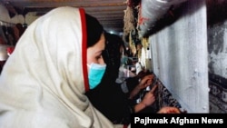 Women weaving carpets in Afghanistan