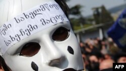 A masked activist at an anti-Saakashvili rally in front of the parliament building in Tbilisi