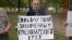 Yana Antonova holds a sign reading: "Freedom to political prisoners of Krasnodar region".
