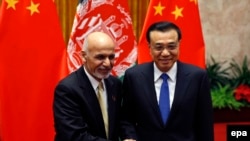 Chinese Prime Minister Li Keqiang and Afghan President Ashraf Ghani (L) pose for pictures during their meeting at the Great Hall of the People in Beijing on October 29, 2014.