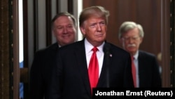 U.S. President Donald Trump arrives flanked by Secretary of State Mike Pompeo (L) and U.S. National Security Advisor John Bolton (R). File photo