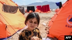 له پاکستانه ستنه شوې افغانه ماشومه په ننګرهار کې د کډوالو په کیمپ کې له خپلې خیمې سره ولاړه ده - انځور له ارشیفه. 