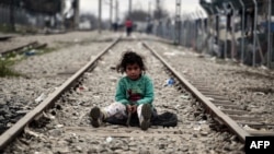 Девочка из семьи беженцев играет посреди железнодорожных рельсов на греческо-македонской границе. 7 марта 2016 года.