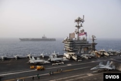 The aircraft carrier USS Abraham Lincoln (CVN 72), back, steams alongside the aircraft carrier USS John C. Stennis (CVN 74) in the Mediterranean Sea, April 24, 2019