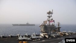 The aircraft carrier USS Abraham Lincoln (CVN 72), back, steams alongside the aircraft carrier USS John C. Stennis (CVN 74) in the Mediterranean Sea, April 24, 2019