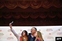 Moldovan Socialist Party presidential candidate Igor Dodon (center) poses for a photograph with supporters while on the campaign trail on October 25.