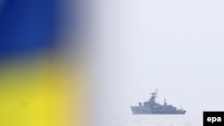 Украинский флаг и российский патрульный корабль "Суздалец" в водах Севастополя. Крым, 2 марта 2014 года. 