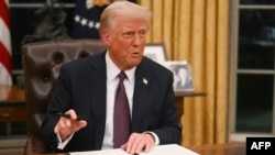 President Donald Trump signs orders in the Oval Office at the White House on January 2o.