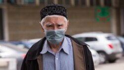 Мужчина в защитной маске идет по улице. Алматы, 9 мая 2020 года.