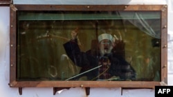 Islamic cleric Muhammad Tahir-ul-Qadri addresses his audience behind bulletproof glass at a rally in Islamabad on January 16.