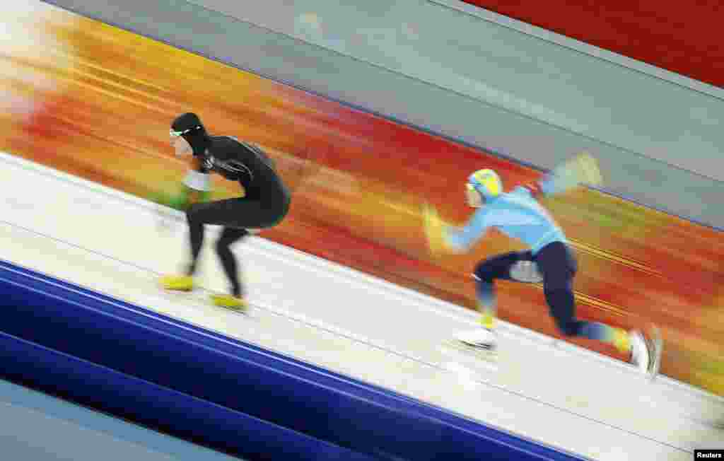 Lauren Cholewinski of the United States leads Kazakhstan's Yekaterina Aydova during the women's 500 metres speed skating race at the Adler Arena.