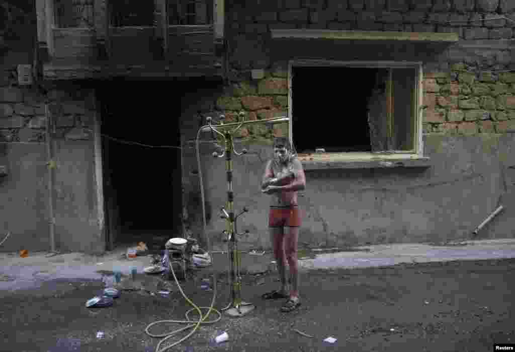 A Free Syrian Army fighter takes a shower outdoors to beat the heat in Deir al-Zor. (Reuters/Khalil Ashawi)